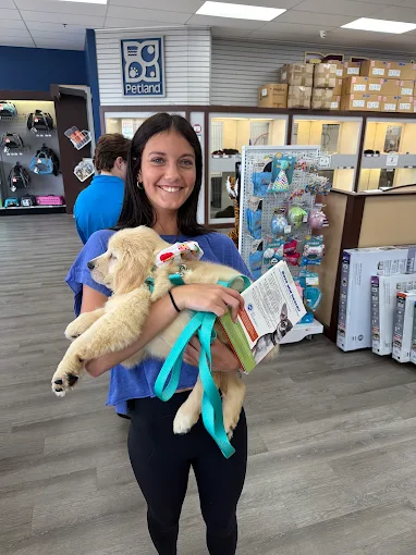 A new pet parent holding a puppy and take-home materials