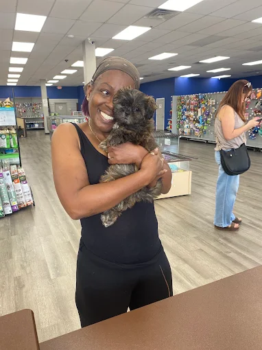 A Petland Robinson customer holding a puppy